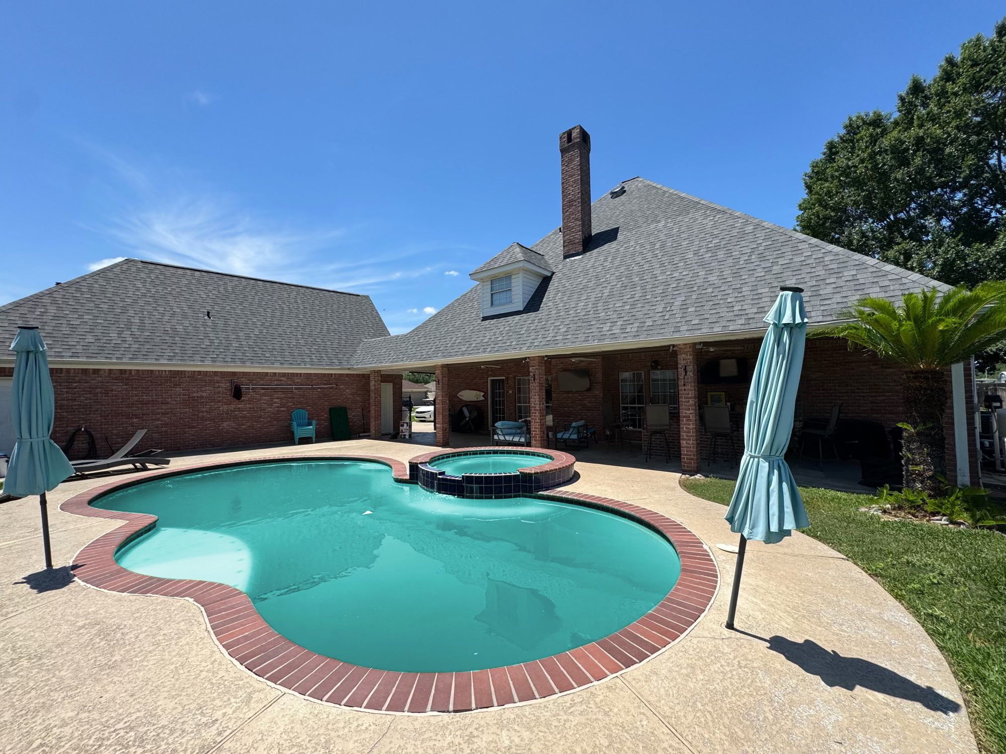 Backyard pool and new roof on a home completed by Krown Roofing and Construction in Southeast Texas